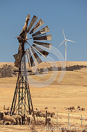 Old wind pump and new wind generators distorted by hot air. South Australia. Stock Photo