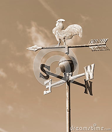 old wind vane with cock in iron in sepia toned Stock Photo