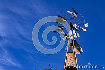 Old windmill made of metal to extract water. Stock Photo