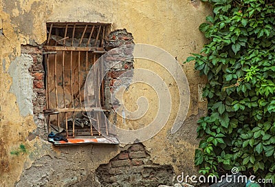 Old window with metal grid on an old peeling abandoned wall with Stock Photo