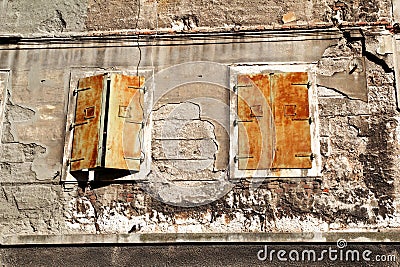 Old window with rotten and cover rusty iron shutters on building in Pula, Croatia, closeup / Building facade elements, material. Stock Photo