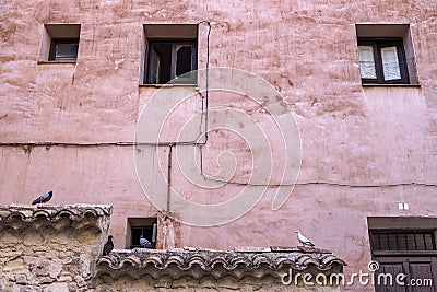 Old windows in a facade painted pink, Cuenca Stock Photo