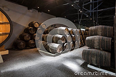 Old wine cellar with big and small wooden barrels for traditional winemaking Stock Photo