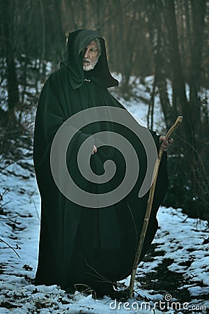 Old wise man with staff in the wood Stock Photo