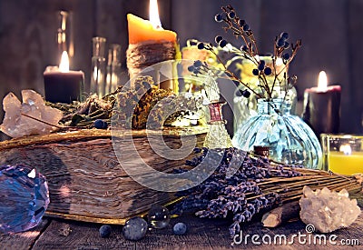Old witch book with lavender flowers, crystal and evil candles Stock Photo