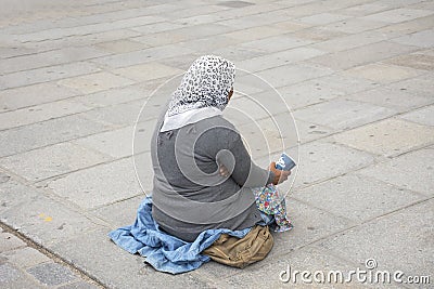Old woman beggar sitting begging money from people Editorial Stock Photo