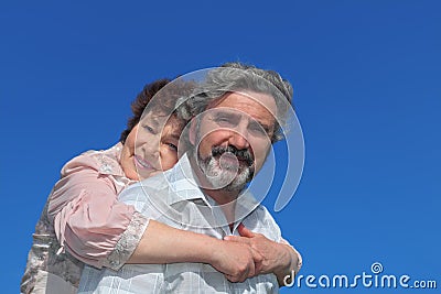 Old woman embracing man from back and smiling Stock Photo