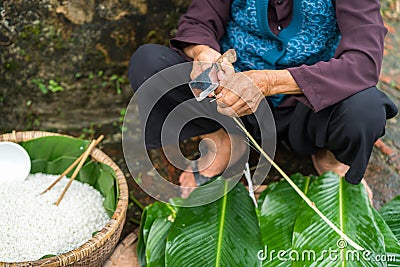 Old woman hands preparing to make Chung Cake, the Vietnamese lunar new year Tet food Stock Photo