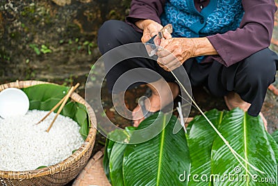 Old woman hands preparing to make Chung Cake, the Vietnamese lunar new year Tet food Stock Photo