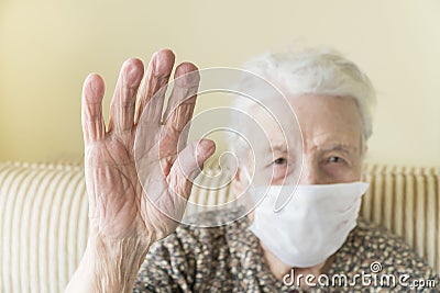 Old woman with health mask making stop sign with wrinkled hand Stock Photo