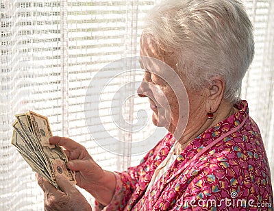 Old woman holding money in hands Stock Photo