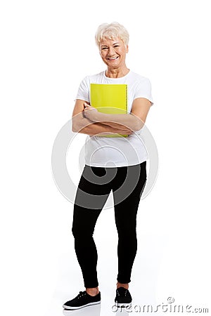 An old woman holding a workbook. Stock Photo