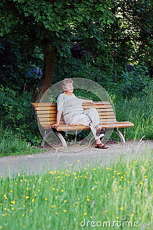 Old woman on a park bench thinking Stock Photo