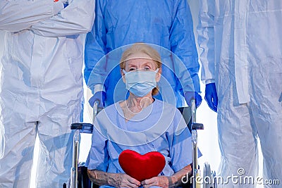 Old woman patient hold mini heart on a wheelchair Stock Photo