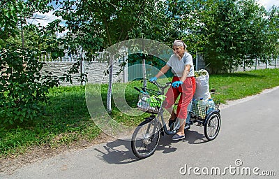 An old woman rides a bicycle. Selection focus. Stock Photo