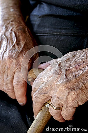 Old woman`s hands holding a cane Stock Photo
