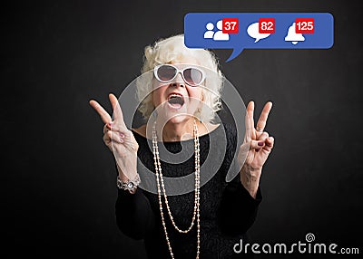 Old woman still rocking and being active on social media Stock Photo