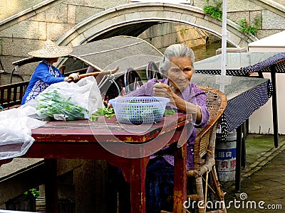 Old woman triming vegetables for cooking Editorial Stock Photo
