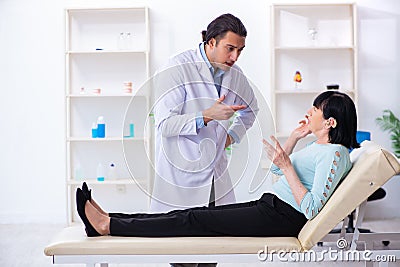 Old woman visiting young doctor laryngologist Stock Photo