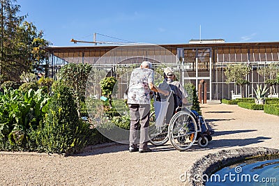 An old woman walking in the Park of her disabled husband Editorial Stock Photo