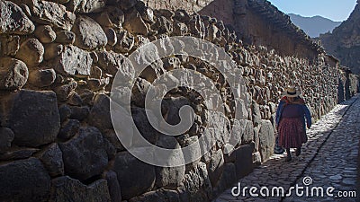 Old woman walking by the streets of Ollantaytambo Editorial Stock Photo