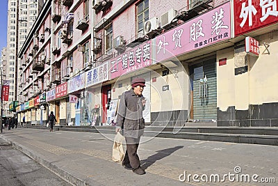 Old woman walks on the street in Beijing, China Editorial Stock Photo