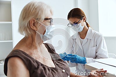 old woman wearing medical mask next to the doctor vaccine passport Stock Photo