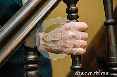 Old woman wrinkled hands hold the handrail Stock Photo