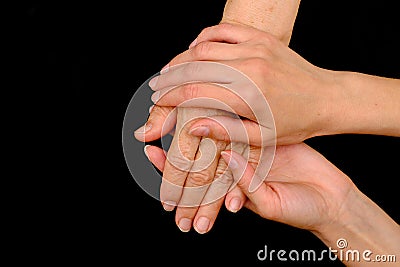 Old woman and young woman holding hands together Stock Photo