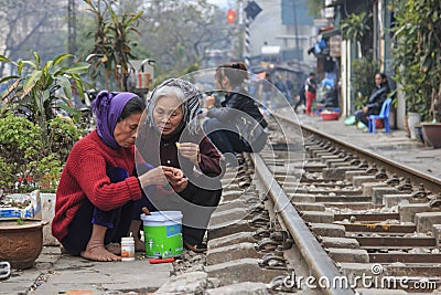 Old women eating on the railway in the center of Hanoi Editorial Stock Photo