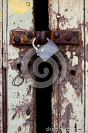 Old wood rural door with old rusty padlock Stock Photo