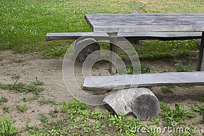 Old wooden bench and table made of solid round timber, outdoor recreation Stock Photo