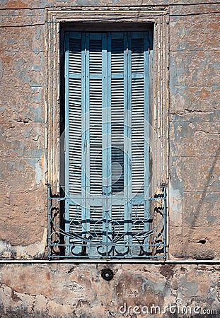 Old wooden blue window with metal hence in old house in decay Stock Photo