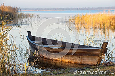 Old wooden boat on the shore of lake Zuvintas at sunrise, nature landscape, Lithuania, tranquil early morning Stock Photo