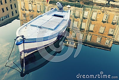 Old wooden boat, sky and ancient historical and building with reflection on blue water Stock Photo