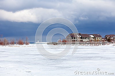 An old, wooden bridge crosses a section of frozen Georgian Bay waterfront in Collingwood Stock Photo
