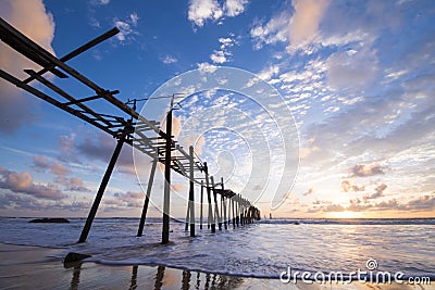 Old wooden bridge at Natai beach with beautiful sky Stock Photo