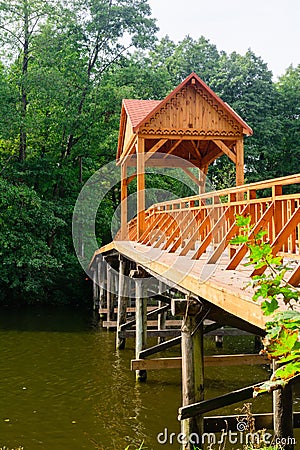 Old wooden bridge over the river with arbor. Forest River. Stock Photo