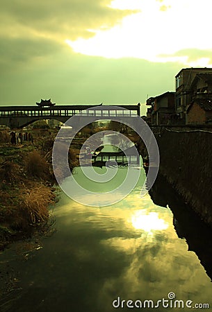 An old wooden bridge spans a river in Wuyishan Stock Photo