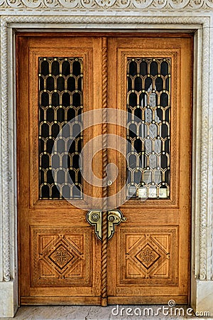 Old wooden carved door with massive bronze handles Stock Photo