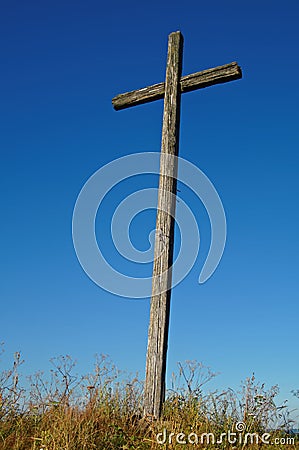 Old wooden cross against a blue sky background Stock Photo