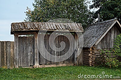 Old wooden dilapidated village house with gate Stock Photo