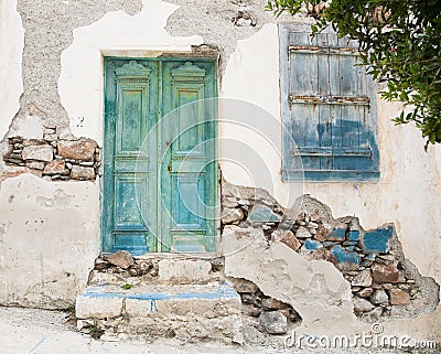 Old wooden door of a shabby demaged house facade or front. Stock Photo