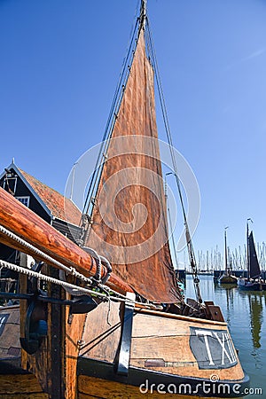 Old wooden Dutch fishing boat with brown sail in the harbor of Enkhuizen Editorial Stock Photo