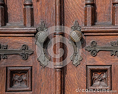 Old wooden exterior doors with decorative panels, brass doorknobs Stock Photo