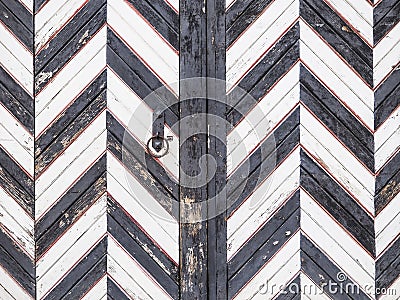 Old wooden gate in black and white stripes. Wooden contrasting background. Stock Photo