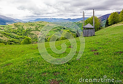 Old wooden hay shed on grassy hillside Stock Photo