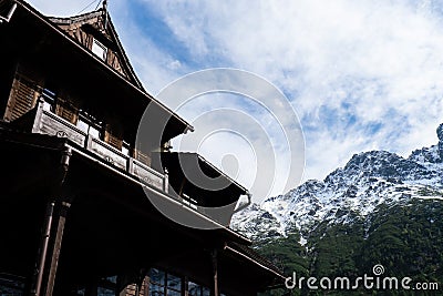 Old wooden house in Snowy mountains, green forests In National park Zakopane Poland. Mountain nature landscape. Blue sky Stock Photo