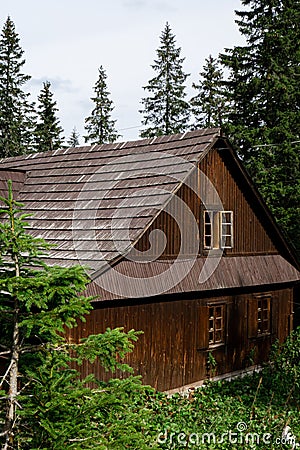 Old wooden house in Snowy mountains, green forests In National park Zakopane Poland. Mountain nature landscape. Blue sky Stock Photo