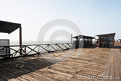 old wooden pier with railing in the pacific ocean and blue sky pimentel chiclayo per Stock Photo